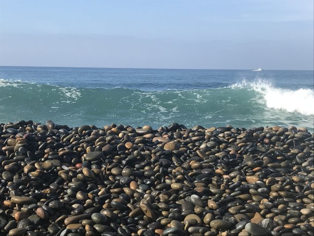 海浪拍打着岩石沙滩。图片下载