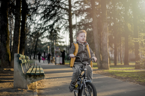 小男孩在公园里骑自行车图片下载