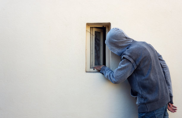 夜贼或小偷通过小窗户窥视，并计划偷东西图片下载