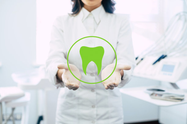 近距离的照片上的牙科医生的手在工作场所的背景，医疗专业人员手持虚拟牙科对象或项目产品。图片下载