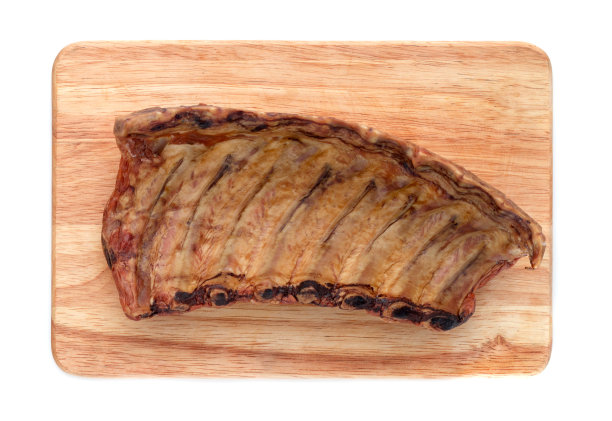 白底烟熏排骨。熏肋在一块木板上，孤立在白色背景上。图片下载