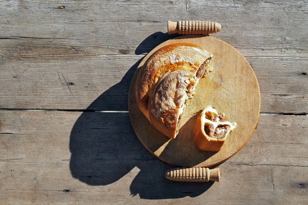 真正手工制作的古巴纳蛋糕，是斯洛文尼亚少数民族在意大利的典型蛋糕，放在户外质朴的砧板上。风化的木头桌子的背景图片下载