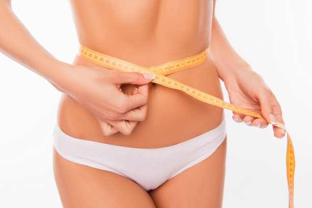 近距离照片的女人的腰围测量与卷尺图片下载