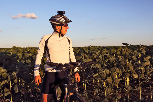 骑着自行车的人在田野里向一边看图片下载