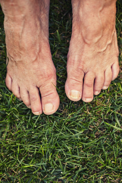 光着脚的老人站在绿色的草地上图片下载