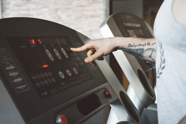 一个有纹身的人在设置跑步机图片下载