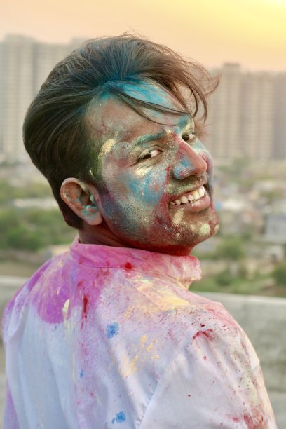 印度教印度男子在胡里节的色彩和爱笑覆盖在油漆粉颜色的gulrang，油漆战斗的照片图片下载