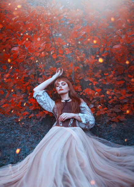 温暖的艺术照片睡美人，女孩与火红的头发躺在浓密的森林在明亮的黄色阳光下橙色的树叶下，奇妙的被施了魔法的公主，新的故事关于白雪公主图片下载