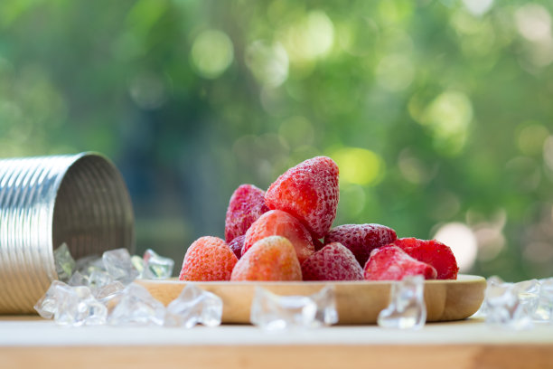 冷冻草莓与模糊的绿色自然背景图片下载