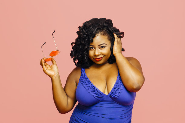 一个穿着泳衣戴着墨镜的性感大码模特的肖像图片下载