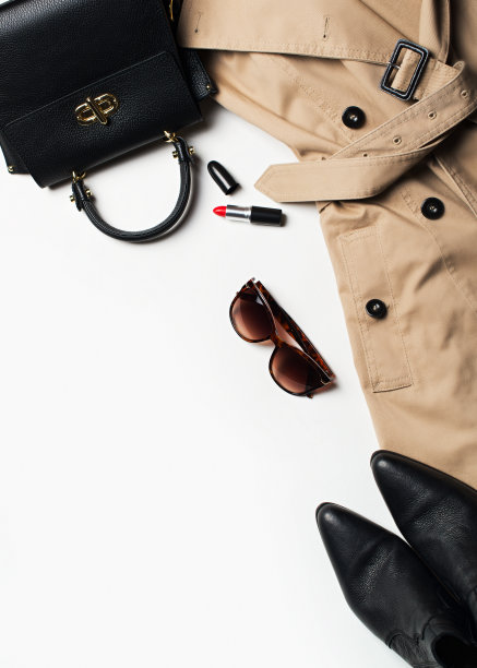 女性时尚服装和配饰平铺，米色风衣配包包，眼镜和西式靴子图片下载