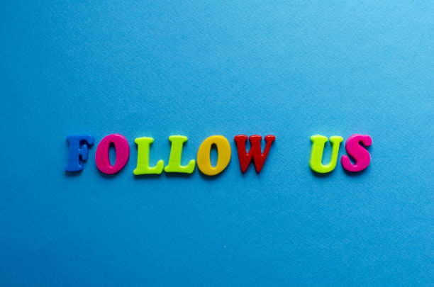 文字跟随我们从塑料彩色字母在蓝色的纸背景图片下载