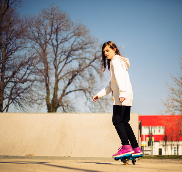 年轻漂亮的少女在滑板公园玩滑板图片下载