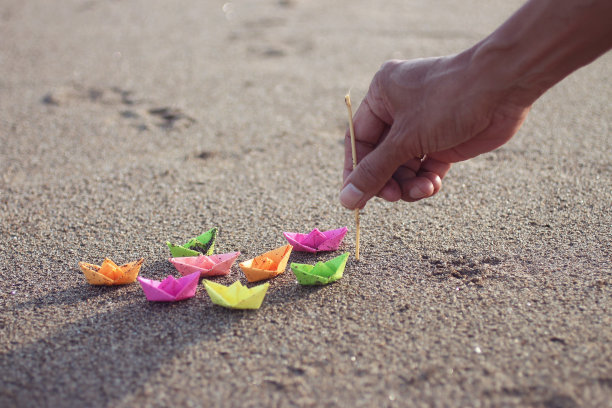 彩色纸船，一只手拿着棍子图片下载