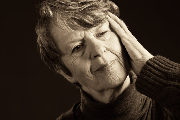 年长的女人，手放在头上，思考着或痛苦着图片下载