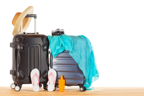 暑假的概念。带草帽、蓝色pareo、人字拖、防晒霜瓶子和复古相机的行李箱，映衬着白色孤立的背景。图片旅游和度假模型。图片下载