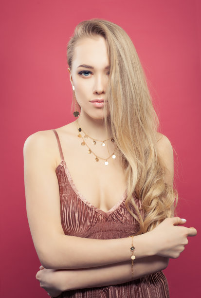 漂亮女人肖像。美丽的女孩模型与长卷发和自然的化妆在粉红色图片下载