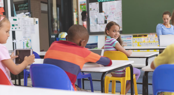 快乐的女学生在教室里看着摄像机图片下载