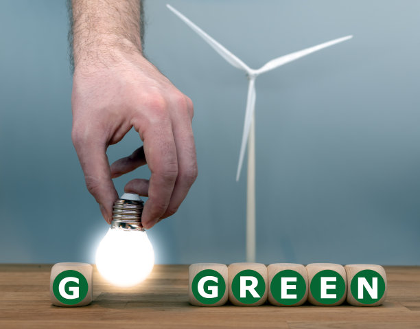 骰子和灯泡构成了“变绿”的表达。背景是一个风力涡轮机模型。图片下载
