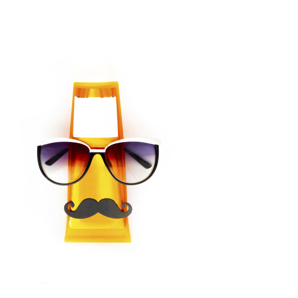 橙色的防晒瓶与黑色的胡子和深蓝色的太阳镜把像人的脸放在水平空白的白色背景与复制空间。假日当代平铺。图片下载