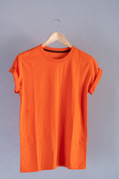 复古折叠橙色棉t恤衣服模仿模板在垃圾白色木材背景概念零售服装店的背景，空白平铺复古灰色木制朴素的洗衣广告图片下载