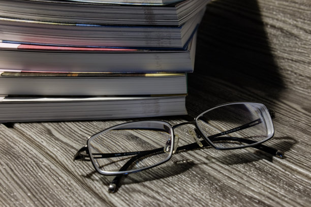 一副眼镜放在一堆书旁边图片下载