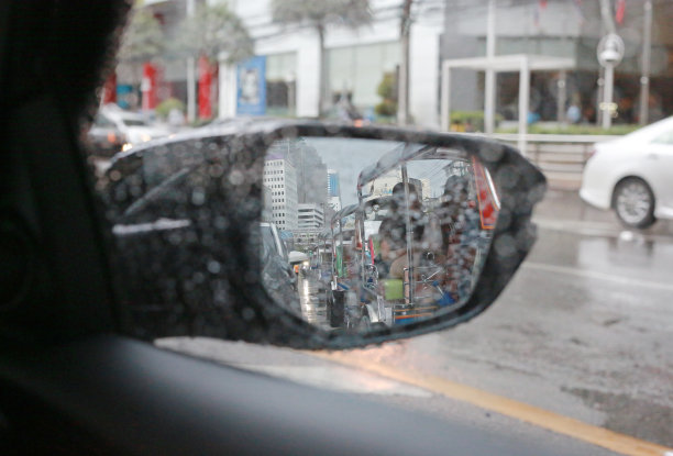 汽车后视镜与模糊的雨滴。图片下载