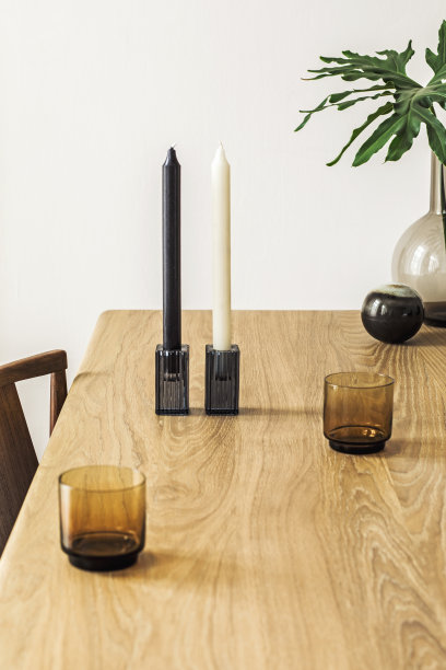 近距离的时尚和极简主义的室内花瓶，木制桌子和蜡烛热带树叶。现代化的房间与设计配件。家居装饰。细节。真实的照片。图片下载
