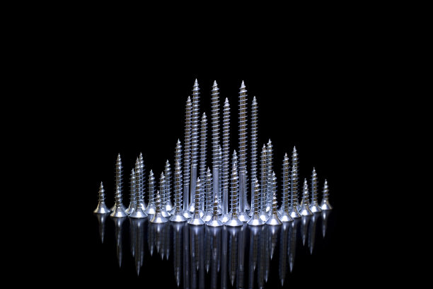 不同尺寸的自攻螺钉在黑色背景反射图片下载
