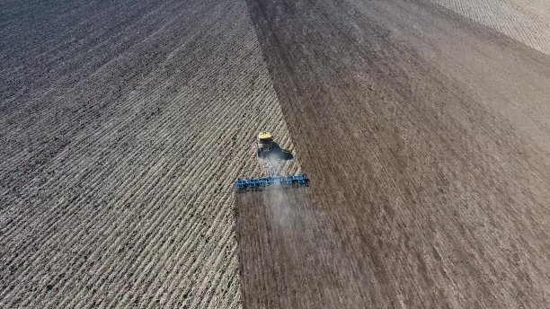 拖拉机耙地里的泥土以便播种图片下载