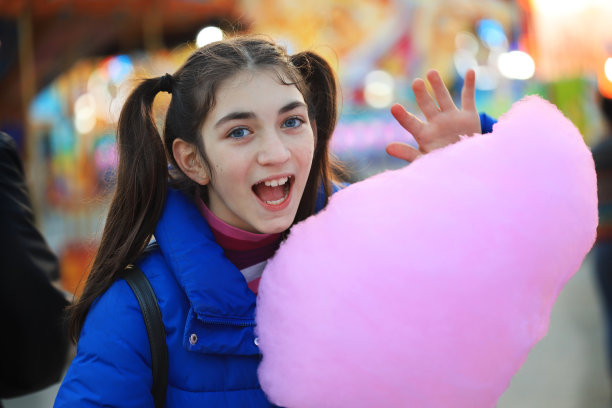 在游乐场吃棉花糖的女孩图片下载