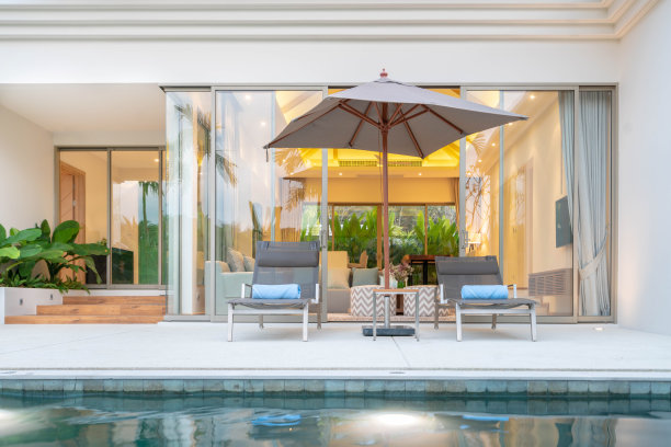 外观设计展示热带泳池别墅，绿植花园，太阳床，雨伞，泳池毛巾图片下载