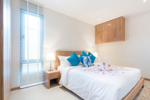 泳池别墅卧室豪华内饰设计，配有舒适的床铺和高挑的天花板，天鹅造型毛巾搭配玫瑰花图片下载