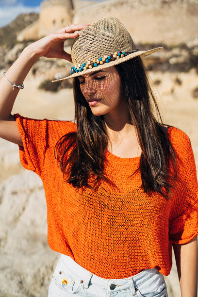 美丽的女人在海滩上，特写的一个漂亮的女性隐藏她的脸从草帽下的太阳，皮肤保护，快乐健康的暑假图片下载