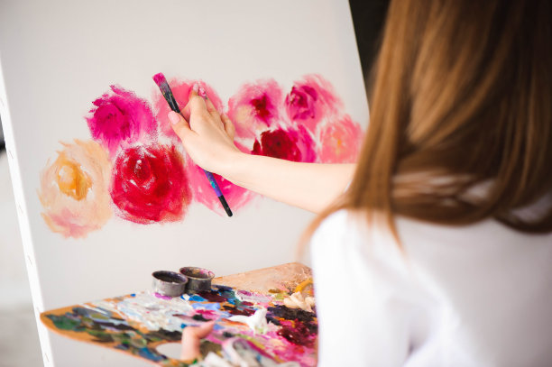 Сute女艺术家在画架上的帆布上作画。工作室模特图片下载