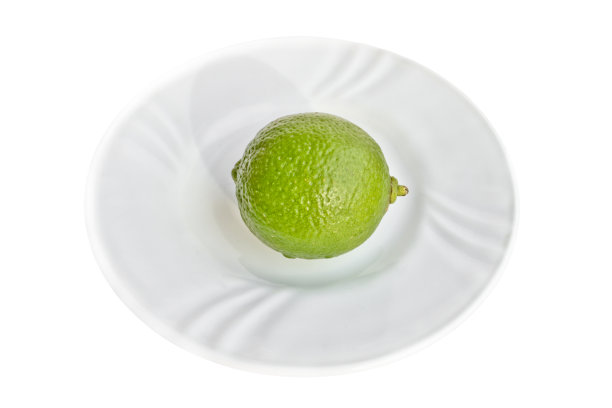 明亮的石灰绿色在白瓷板孤立在白色背景图片下载