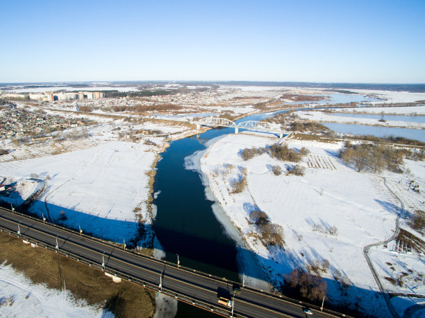 这张照片拍摄的是冬日里的道路、建筑、空地、桥梁和河流。空中城市景观与汽车图片下载