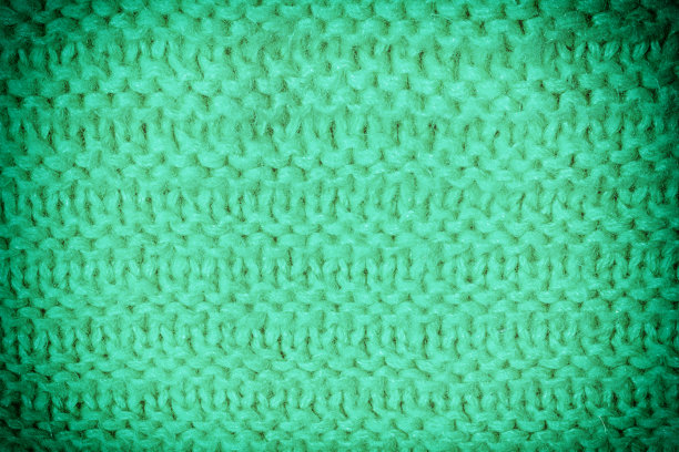 质地的针织产品。不寻常的羊毛图案接近。空白的绿色背景布局。照片与小插图。图片下载