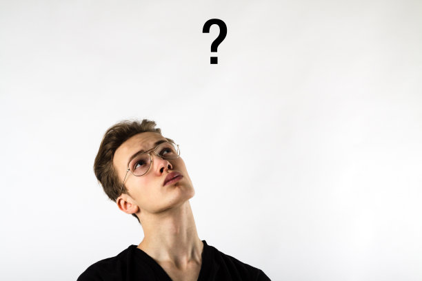 年轻人充满了怀疑和犹豫。年轻人和问号。怀疑和犹豫的概念。图片下载