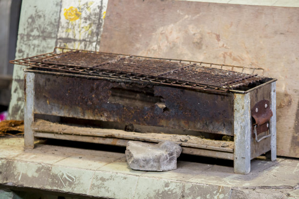 旧的烤架生锈了，放在地板上。图片下载