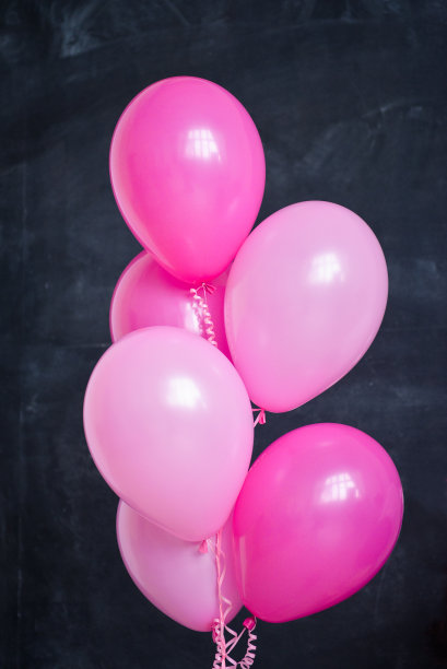 主题生日为一个有趣的情绪化的金发女孩粉碎蛋糕在黑色的背景粉红色。风格化的照片会议传统与甜蜜的装饰和气球图片下载