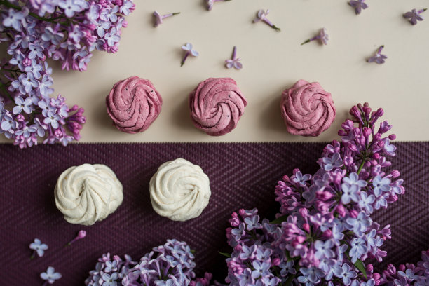 桌上放着粉色和白色的棉花糖和丁香花。厨房里有糖果和食物。图片下载