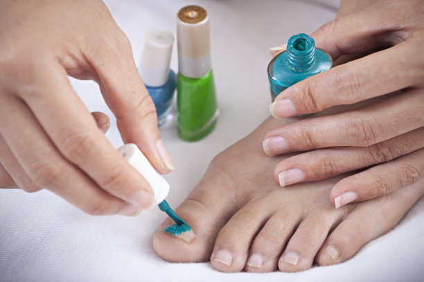 特写的手涂抹指甲油。图片下载