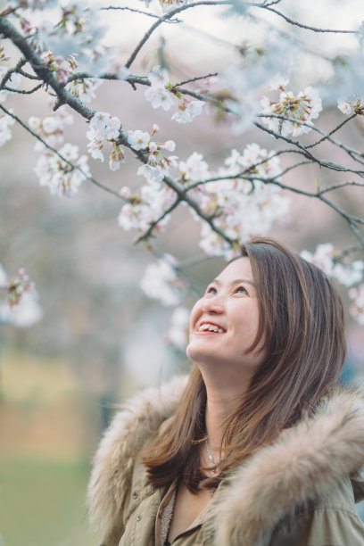 樱花树下年轻快乐的女人的肖像图片下载