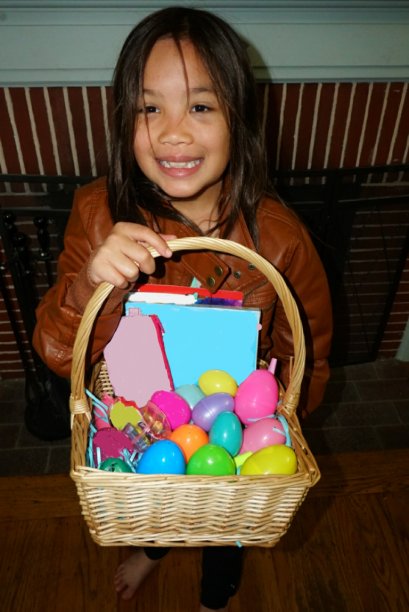 复活节快乐——一个女孩拿着复活节彩蛋礼物篮，脸上挂着大大的微笑图片下载