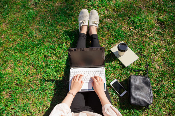 在公园里用笔记本电脑工作的女人图片下载