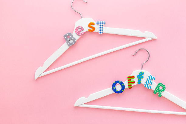 粉红色背景上印有促销文字的白色衣架图片下载