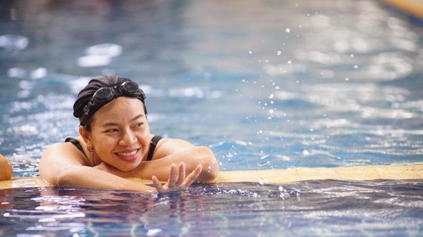 亚洲女子游泳。她是一个快乐的运动。图片下载