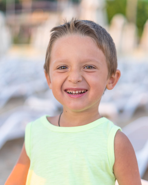 快乐的小男孩和他的家人在海边玩耍的肖像â图片。图片下载