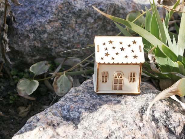 玩具屋在鲜花、树叶和石头之间，春夏季节，图片下载